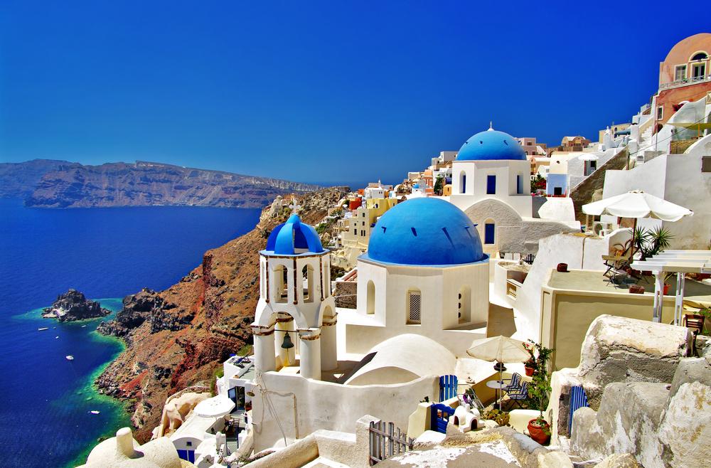 the iconic blue dome churches on the island of Santorini. This is the best spot in town to watch the sunset and is one of the best summer destinations in Europe! 