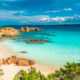 beautiful blue waters with blue sky and clouds and rocks at a beach in Sardinia