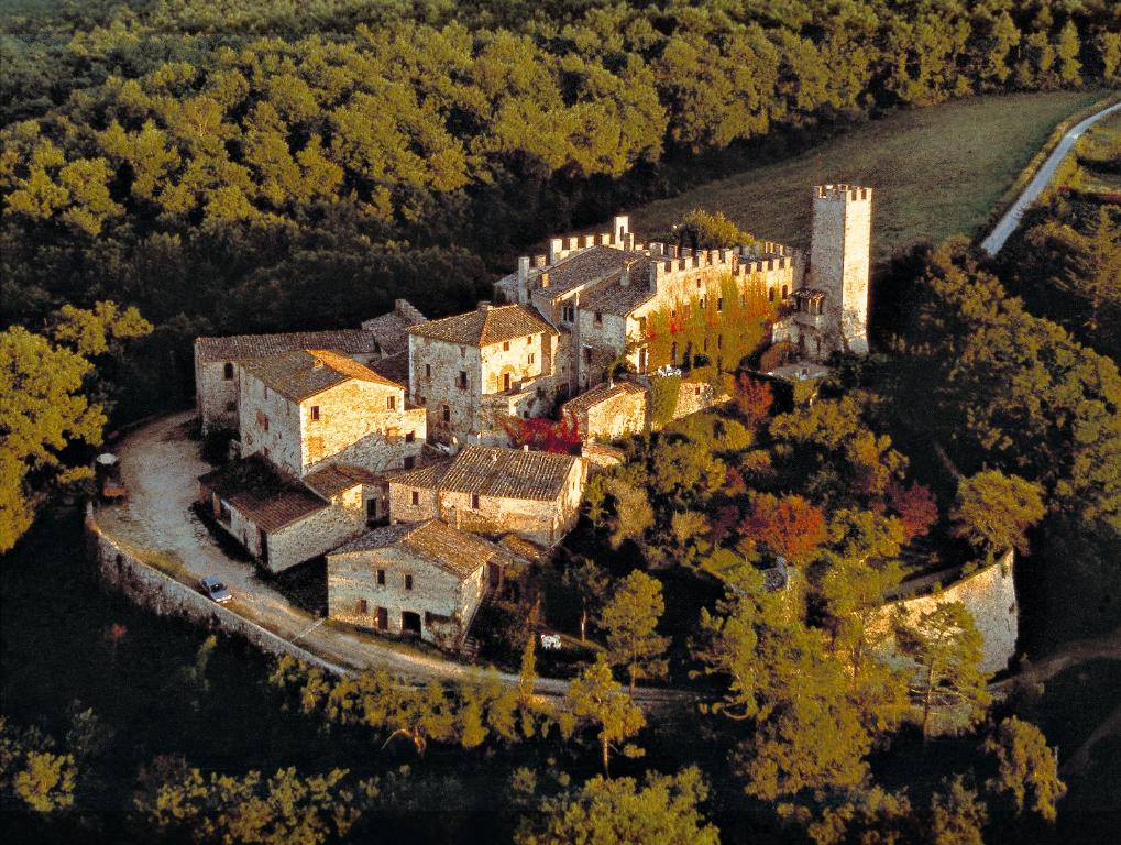 A castle in Tuscany on a hill surrounded by autumn colors