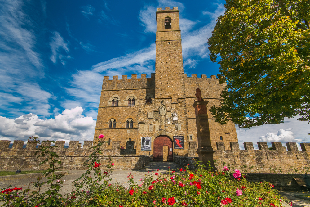Poppi castle or the Castello dei Conti Guidi) is a medieval castle in Poppi, Tuscany. It is sqaure with turrets and there are flowers in front. 