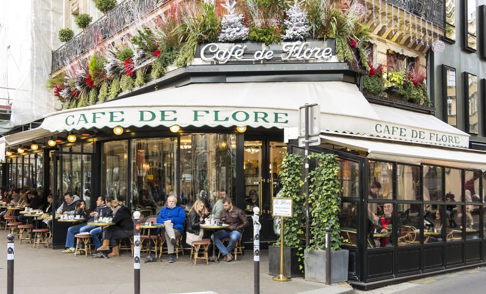 Cafe de Flore is one of the most famous cafes in Paris, with plenty o people gathered outside tables