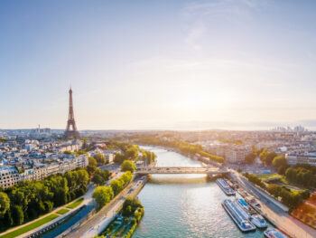 sunrise in paris with Eiffel Tower in the background and buildings and river going through them