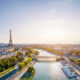 sunrise in paris with Eiffel Tower in the background and buildings and river going through them