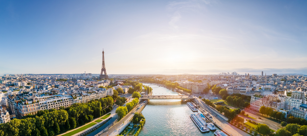 sunrise in paris with Eiffel Tower in the background and buildings and river going through them