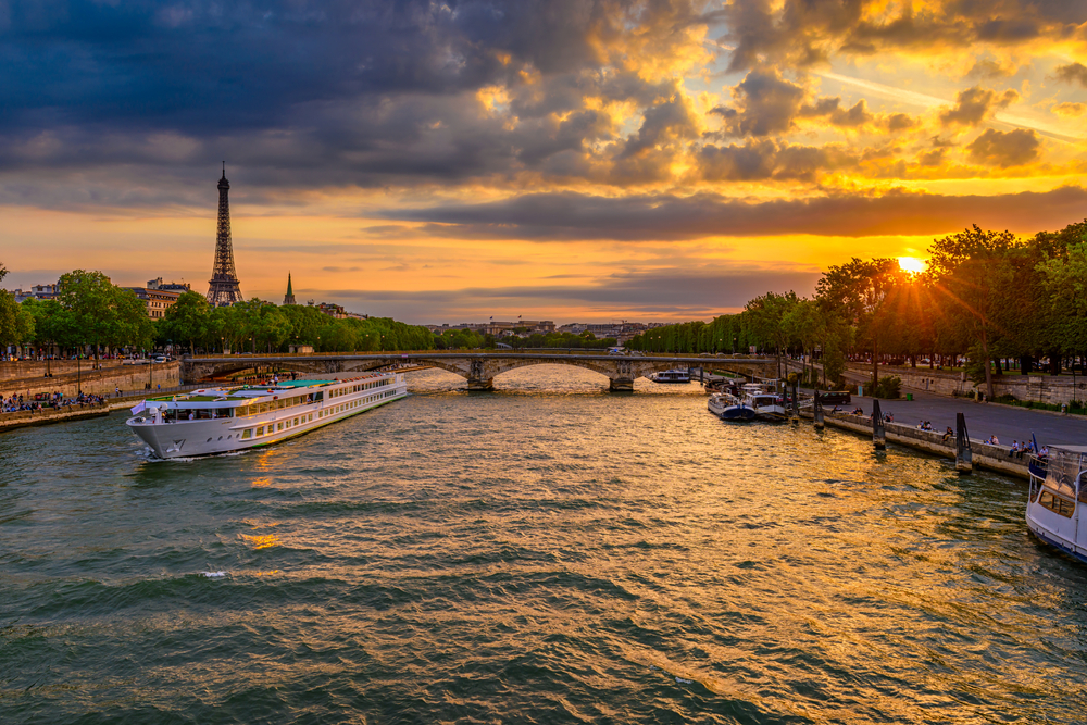 a river boat after sunset with the Eiffle tower int he background 