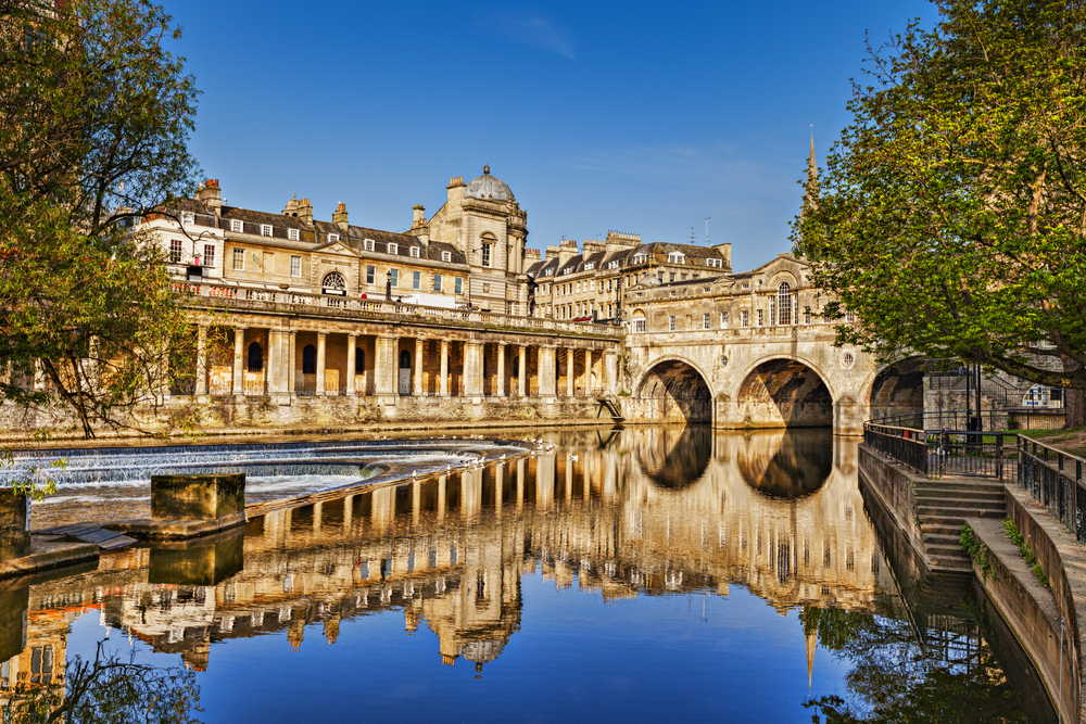 Pulteney Bridge and Weir on the River Avon in the historic city of Bath.  You can see the bridge and an old building and the water. 