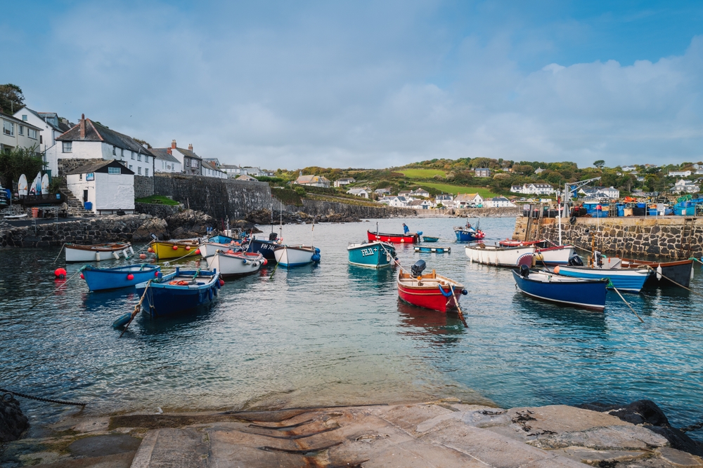 Small boats and fishermen in the Coverack harbour. A coastal village and fishing port in Cornwall, southern England.