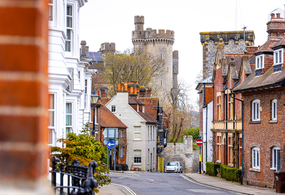 Arundel high street with the castle in the background. You can see old houses either side of the road. The article is about pretty places in Southern England. 