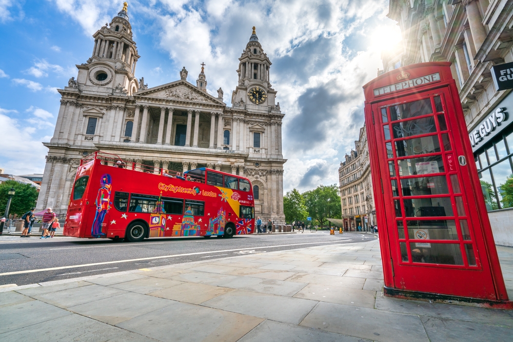 Jump on red hop on hop off bs tour in London with iconic red phone booth and opera building