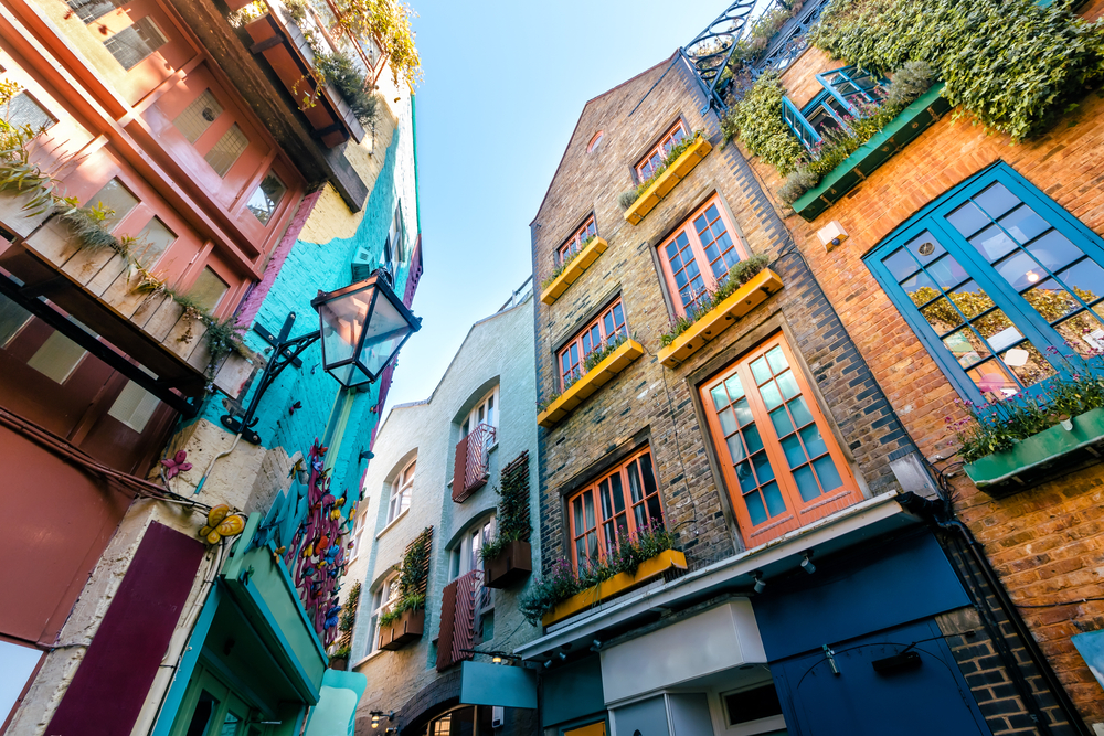 the colorful homes in Neals Yard of Coveent Garden are brick and brightly colored windows with ivy a must-see on your 3 days in London