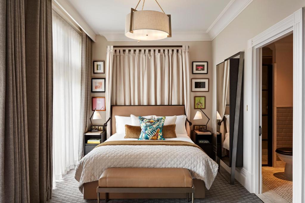 the bedroom at the Kimpton Fitzroy bedrrom with calming colors and pops of artwork