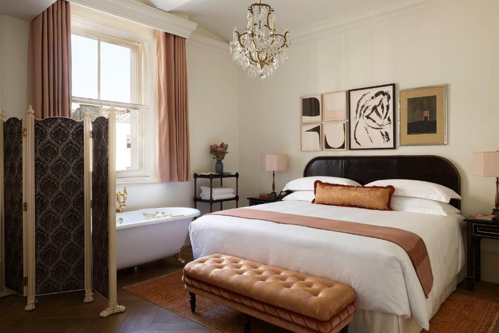 A bedroom with claw foot bathrub and art work at the Nomad London