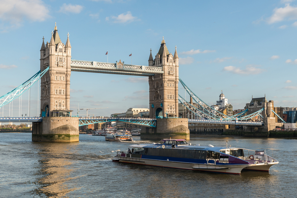 a boat in the Thames River sailing towards Tower Bridge