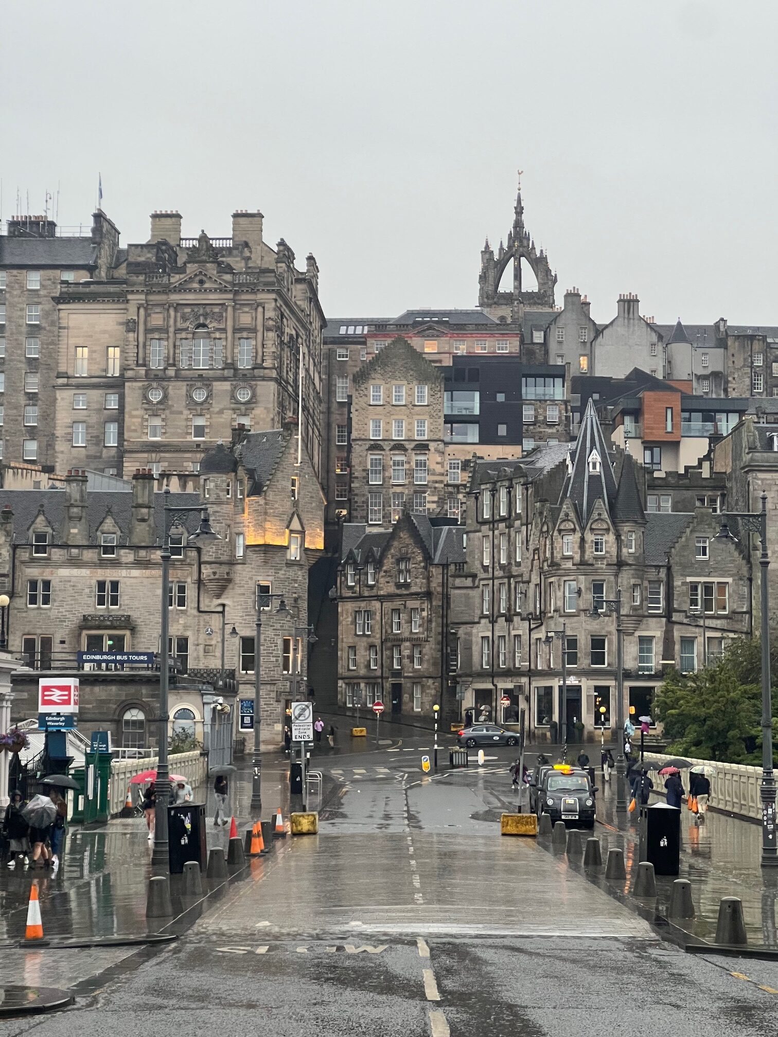 the stacked buildings on Edinburgh's Waverly bridge with rain on the street