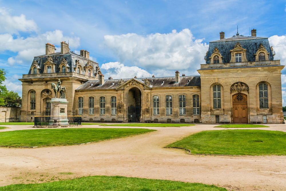 The Grand Stables with a horse statue in front in Chantilly.