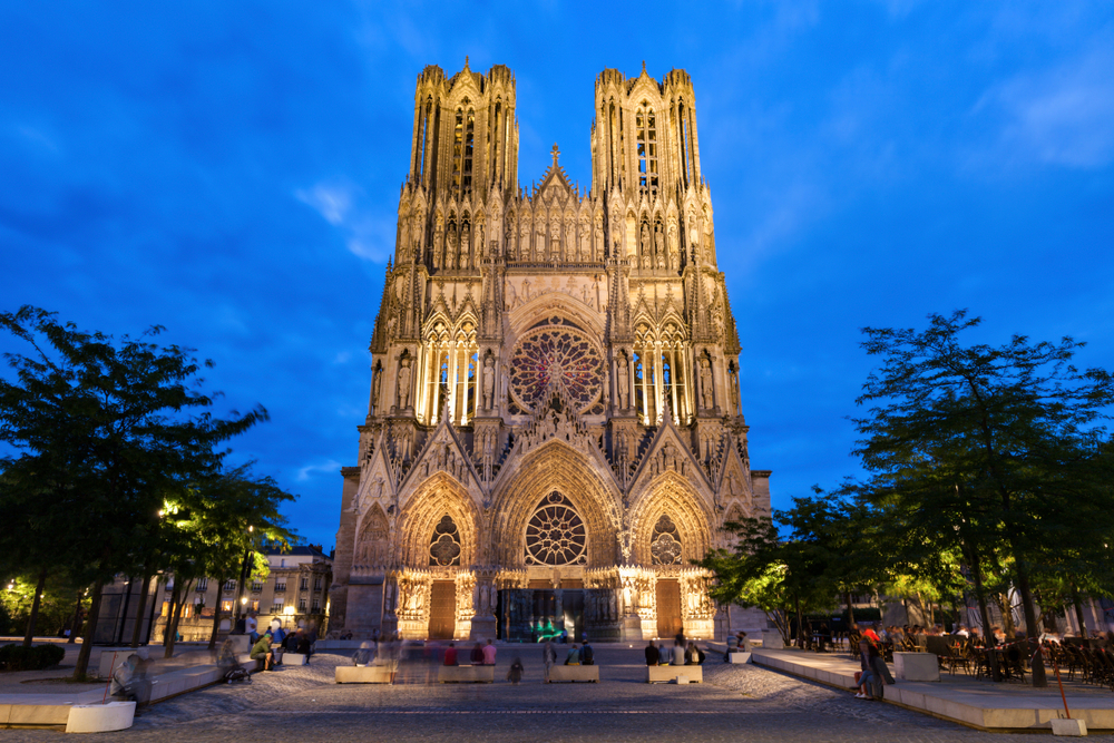 Lit-up Cathedral of Our Lady of Reims at night on a France road trip.