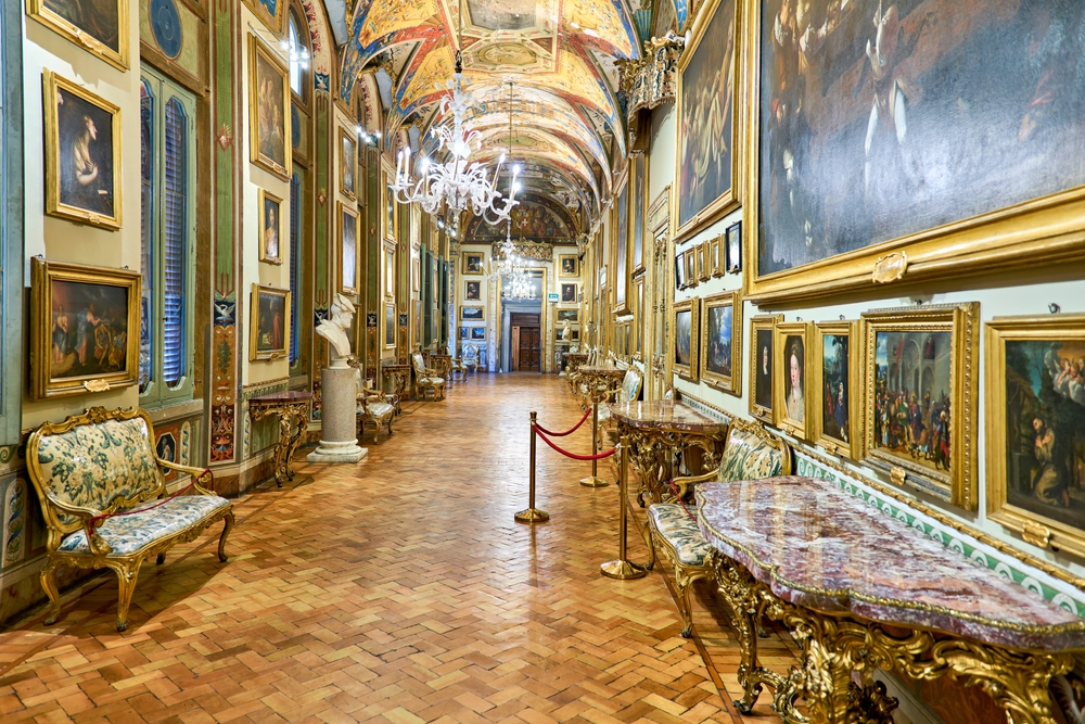 View of an opulent hallway lined with art in Palazzo Doria Pamphilj