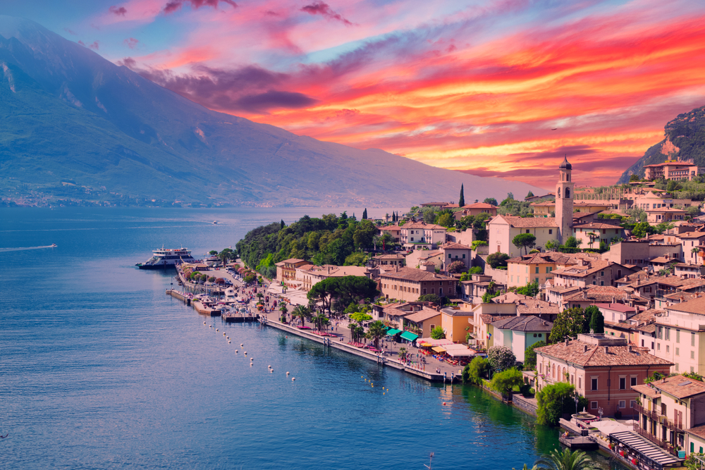 A small town on Lake Garda, Italy at sunset. One of the lakes in Italy. You can   see the water and the town. 