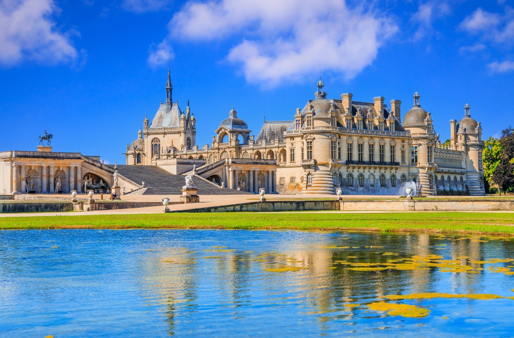 Chantilly Castle (Chateau de Chantilly) View of the northwest facade. Picardie, France across the lake. One of the places to do in Northern France. 