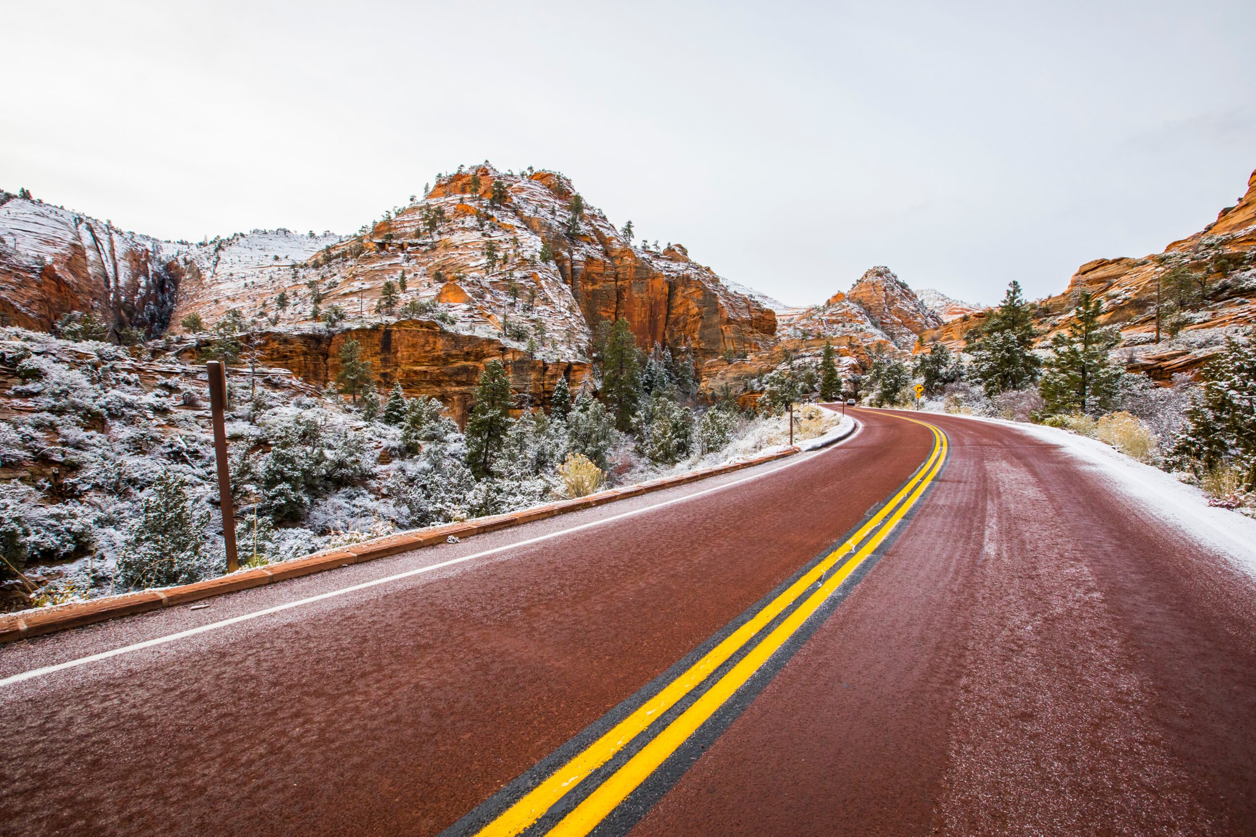 View of a red road winding through Zion National Park in the winter