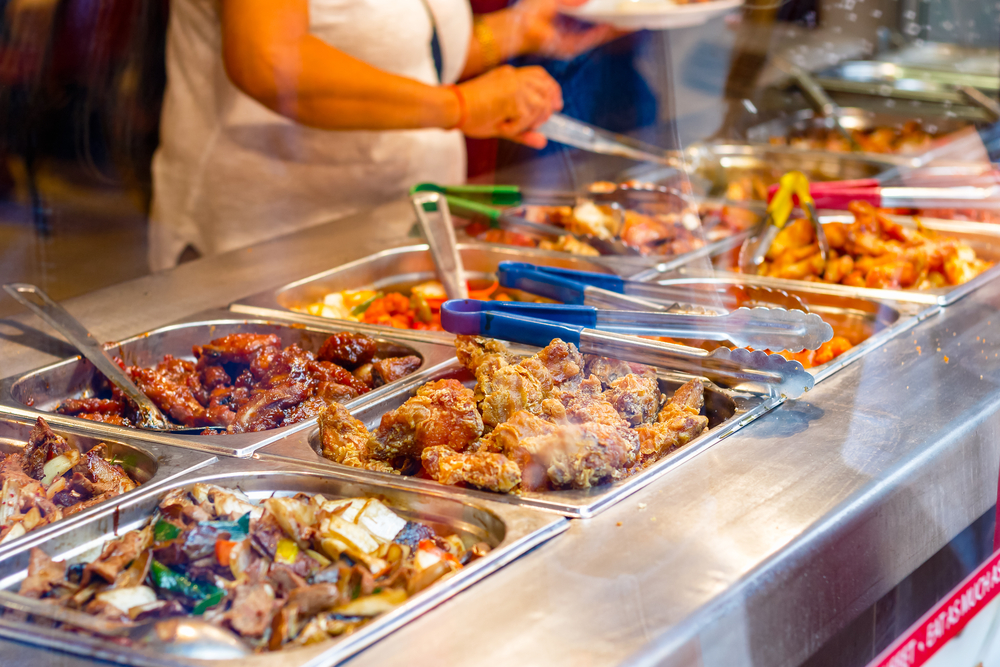 dinner in Chinatown with the abulity to sample a bunch of different dishes as shown here with a woman serving a varity of Chinese dishes