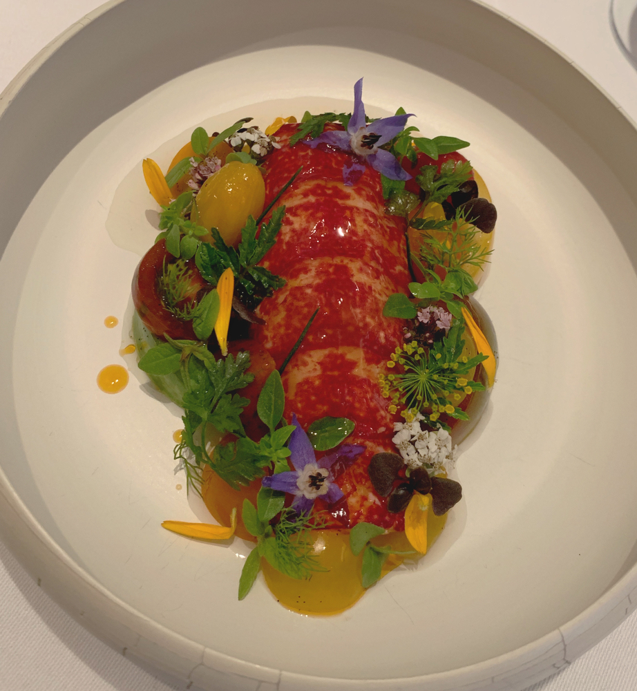 a Michelin Star lobster dish with edible flowers and veggies
