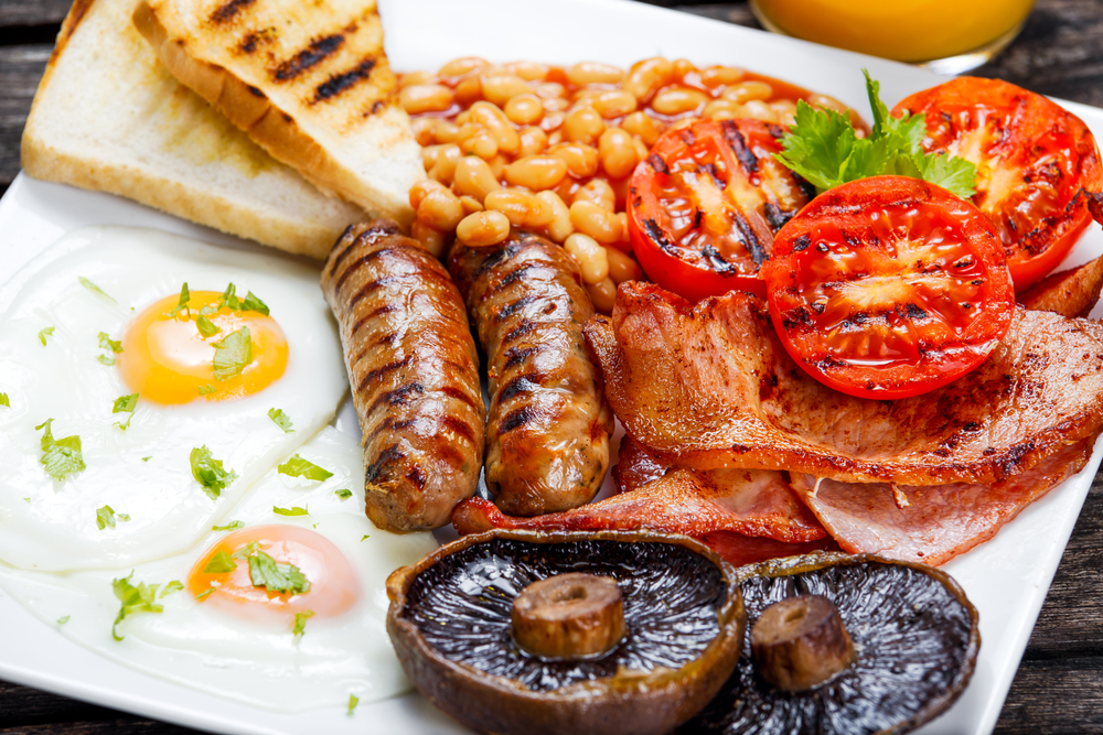 traditional English breakfast. This includes sausage, eggs, tomatoes, mushrooms, bread, and baked beans
