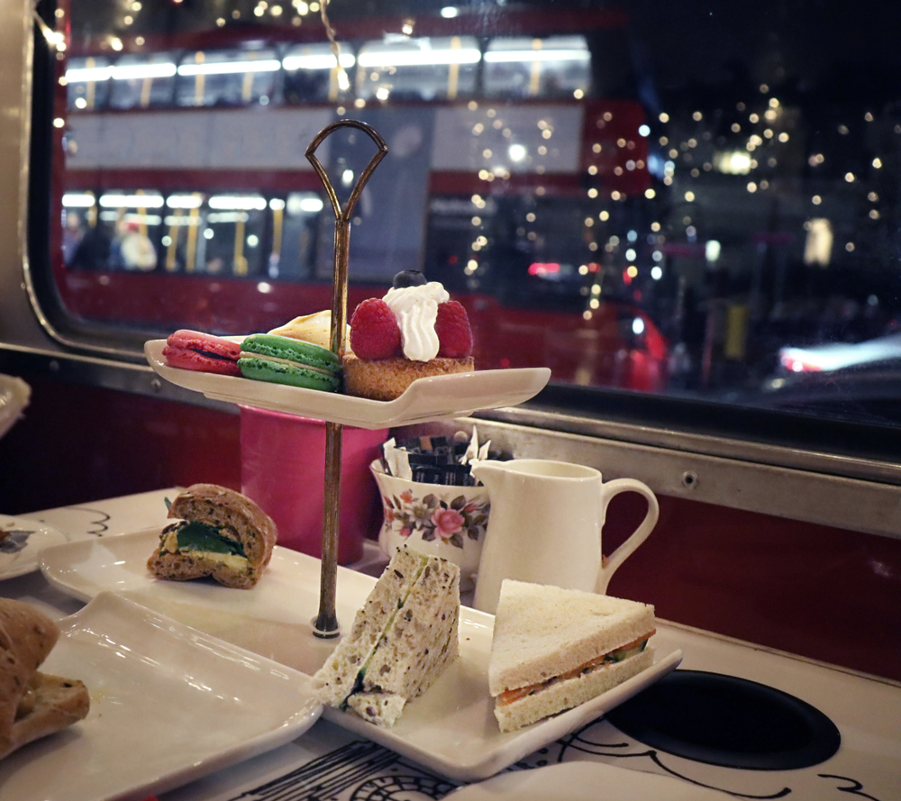 high tea on a bus with sweet treats overlooking London during the holidays