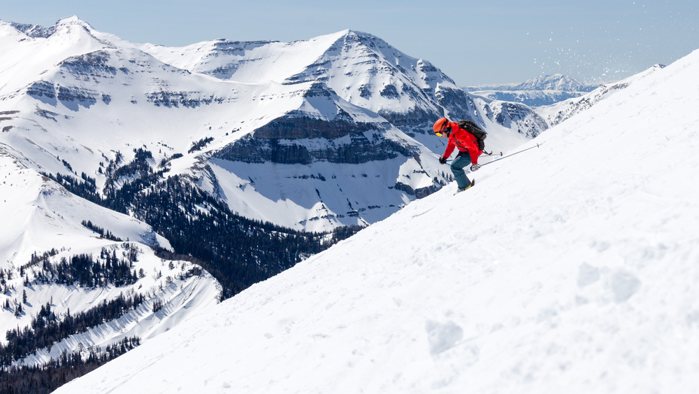 Figure in red skiing down a snowy mountain in Montana.