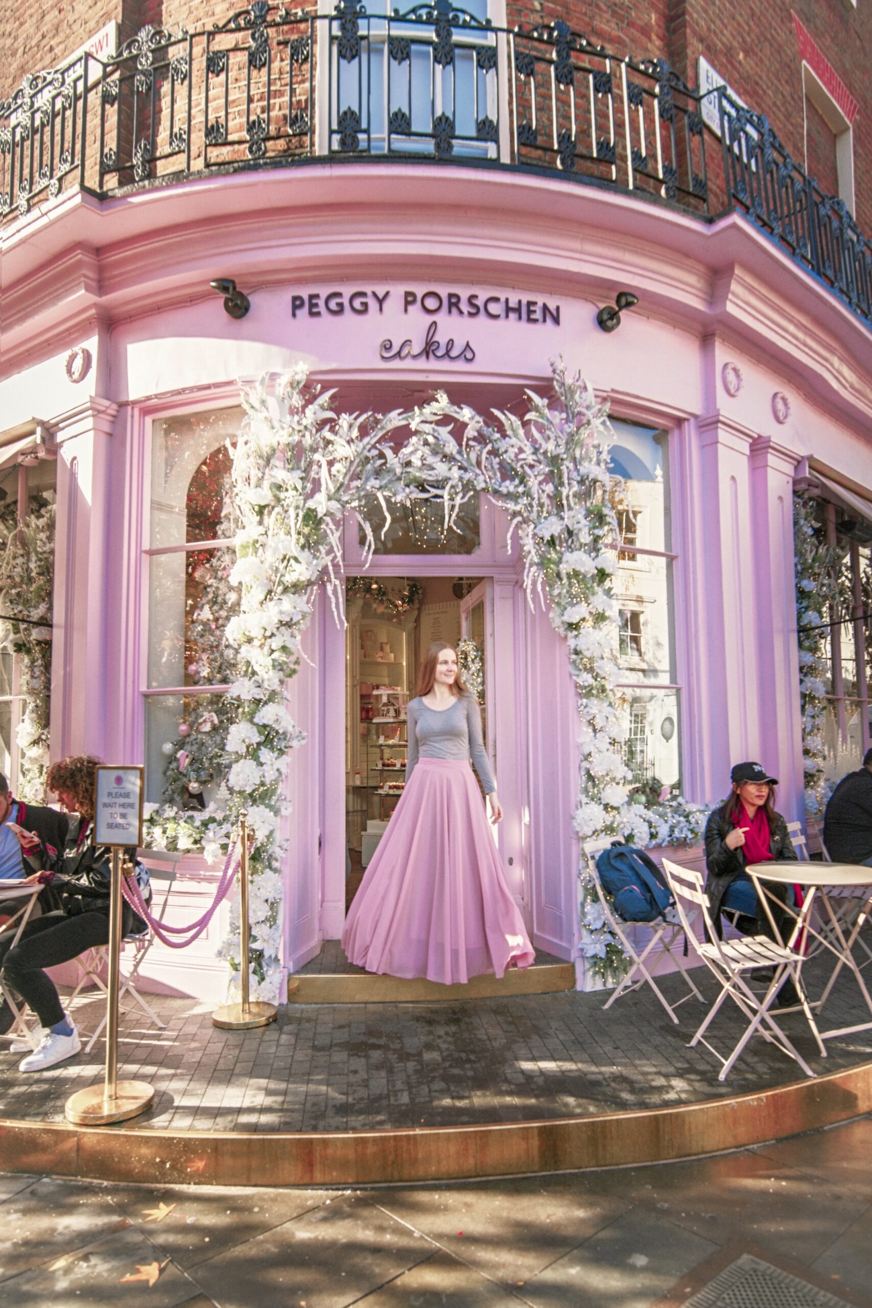 a girl in pink outisde sweets shop in London