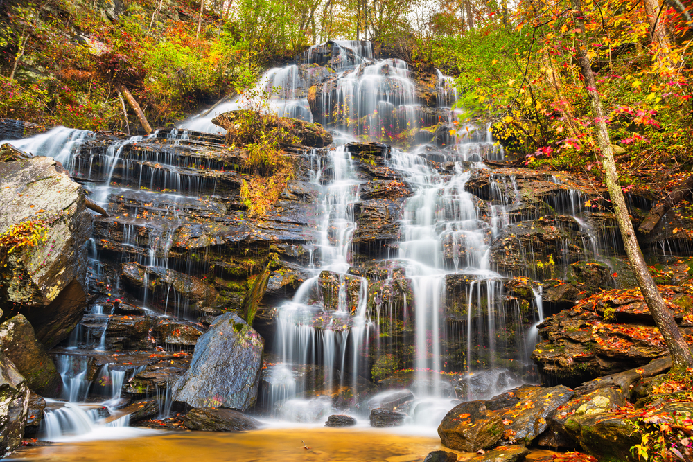 Beautiful tiered Issaqueena Falls cascading down a rock face among fall foliage.