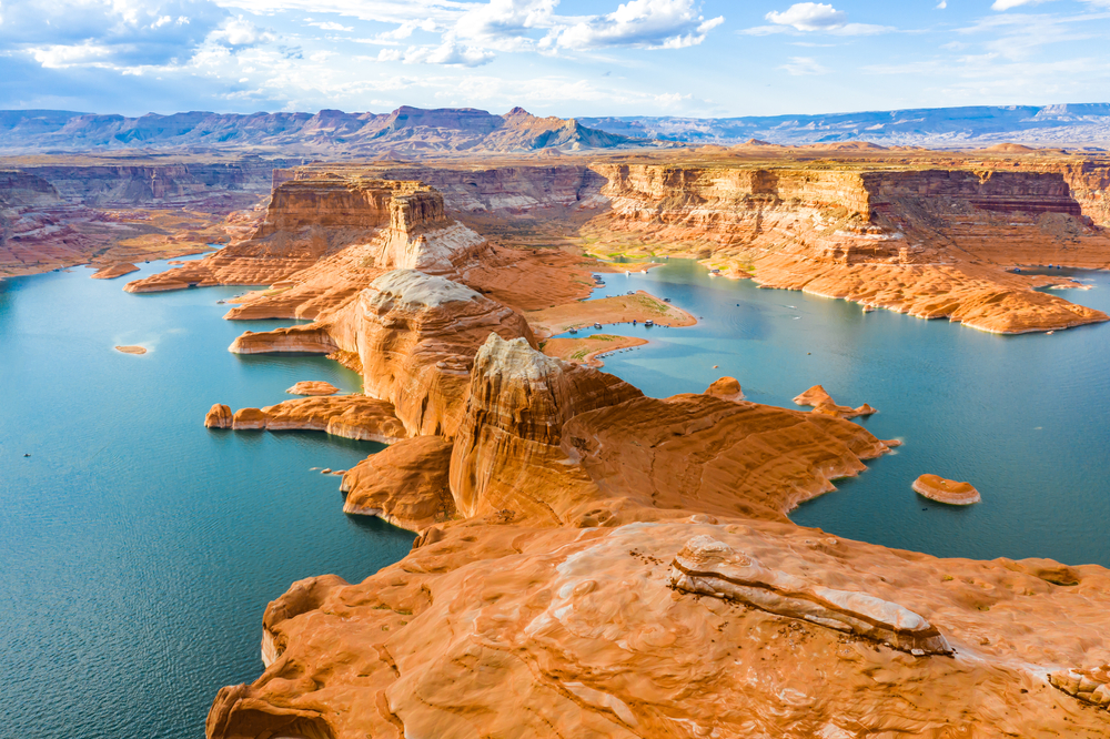 Looking down into Lake Powell among sand colored cliffs and buttes.