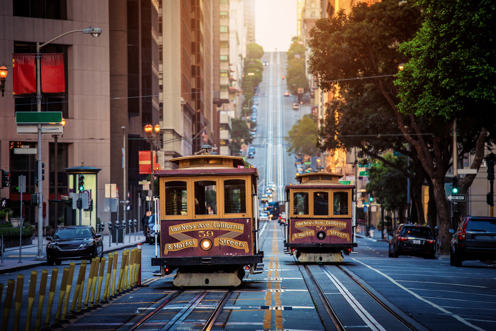 Two trolleys on the streets of San Francisco at golden hour.