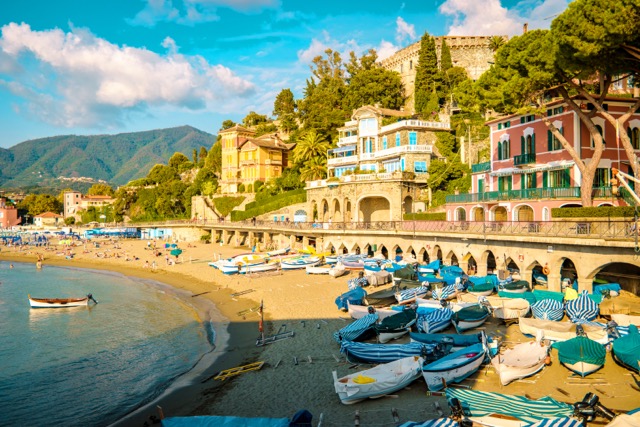 Colorful small boats and umbrellas line Levanto Beach near Cinque Terre