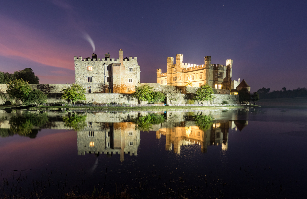 Twilight shot of Leeds Castle across the moat illuminated at Winter. 