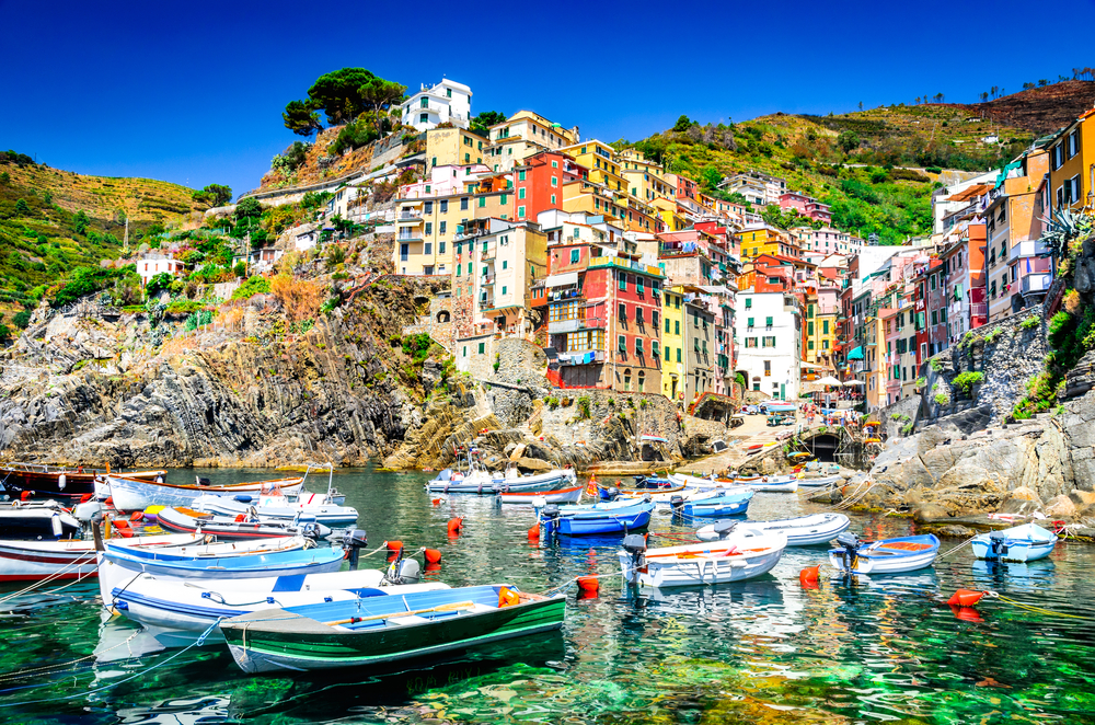  Riomaggiore village in a small valley in the Liguria region of Italy. The picture shows the harbor with boats and the houses behind them. 