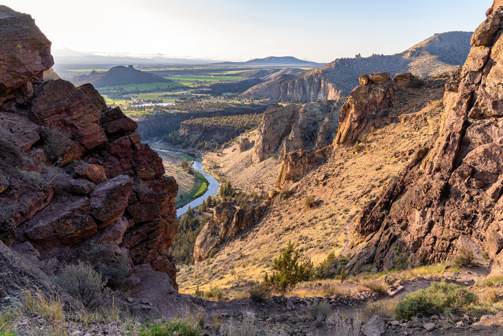 View from the Misery Ridge Hike looking down among rugged cliffs to a river during an Oregon road trip.