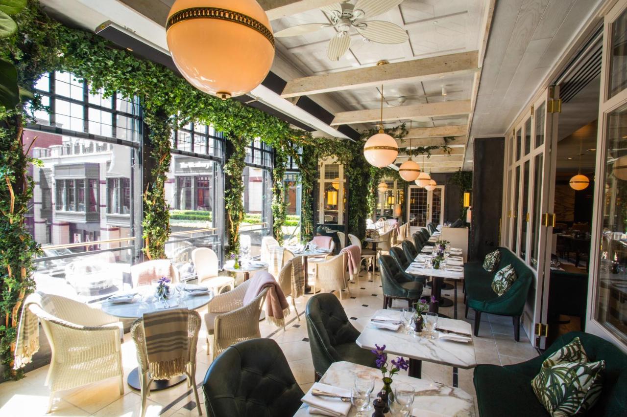 Seating in a restaurant at Westbury Hotel with big windows and greenery.