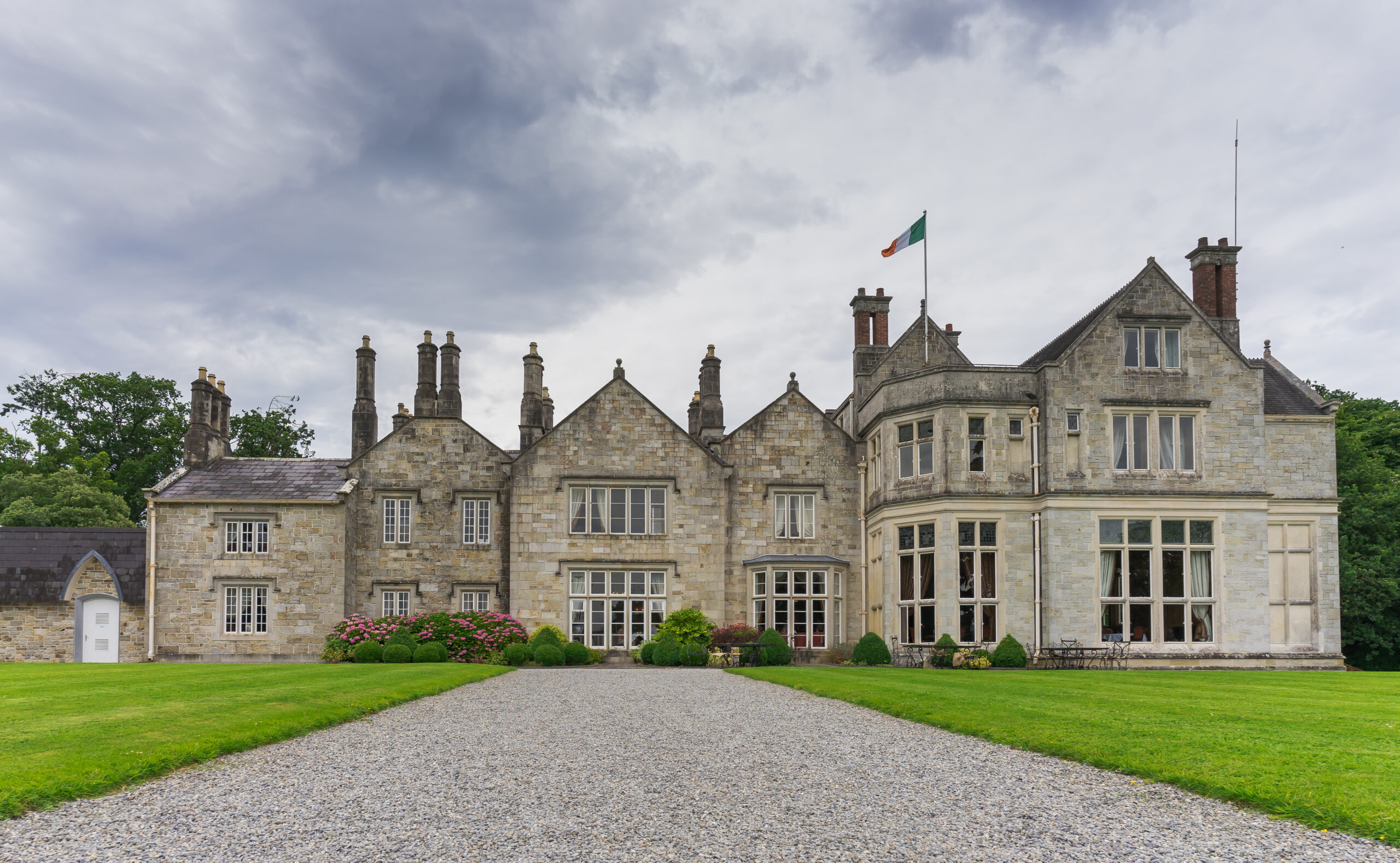 View of Lough Rynn Castle which has tons of windows and is proudly flying an Irish flag. 