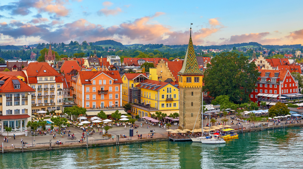 Lindau, Germany at coastline of Lake Constance. Habour along embankment with traditional houses and tower. Sunset evening landscape.