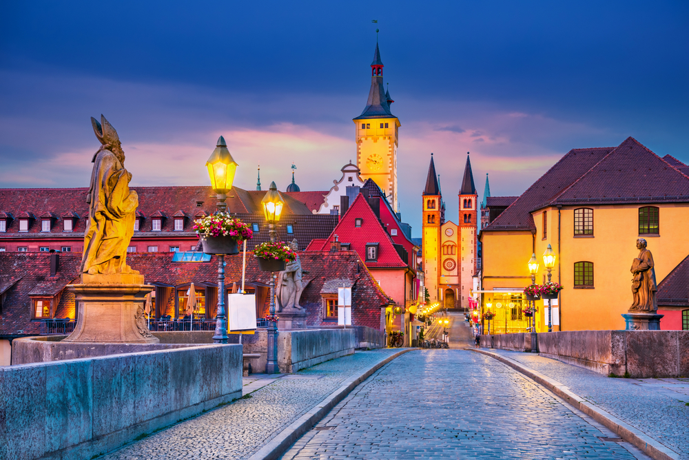 Old Town with cathedral and Old Main Bridge, part of the Romantic Road. You can see the bridge at night with buildings in the background. 