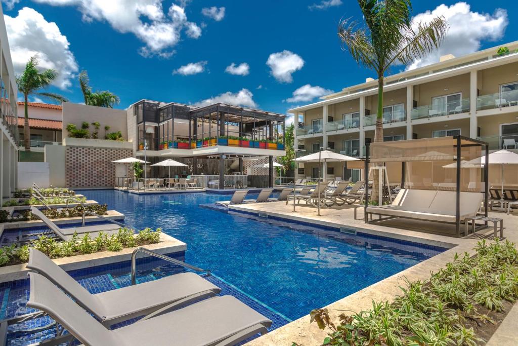 View of the pool surrounded by buildings with a terrace in the background. 