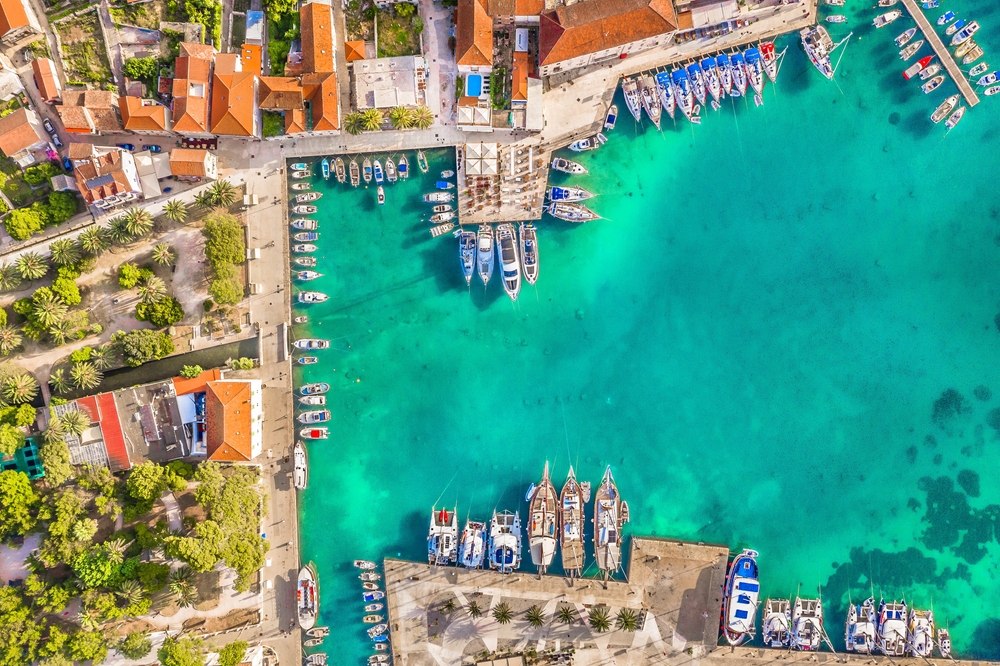 Aerial view of Hvar a harbor town in Croatia. You can see the sea, boats and the town around the harbor. 