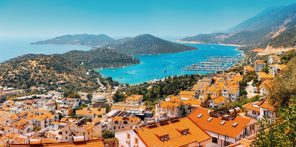 Majestic panoramic view of seaside resort city of Kas in Turkey. Romantic harbour with yachts and boats. Villas and hotels with red roofs are open for tourists. 