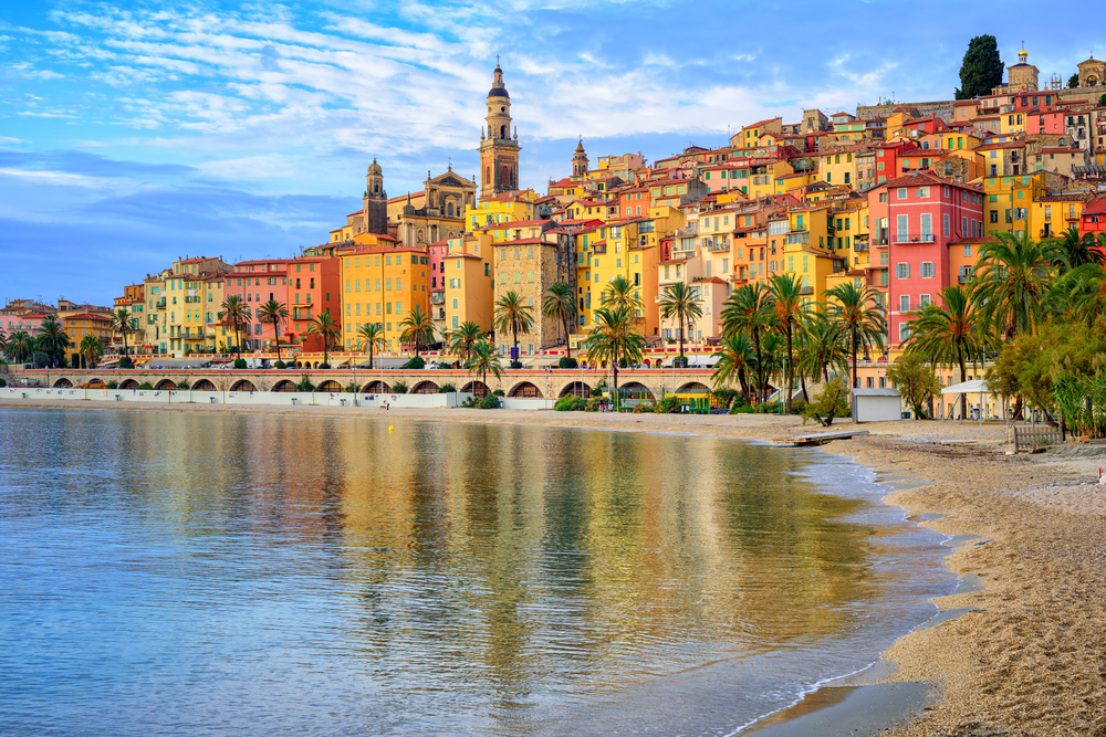 Sand beach beneath the colorful old town Menton on French Riviera, France