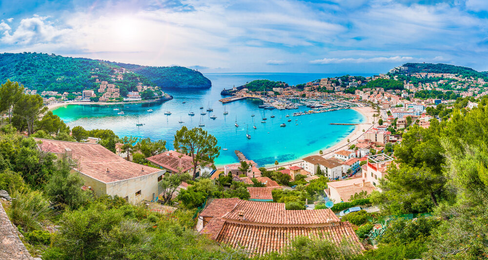 european beach town located along the blue water with houses with brown roofs and blue sky