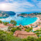 european beach town located along the blue water with houses with brown roofs and blue sky