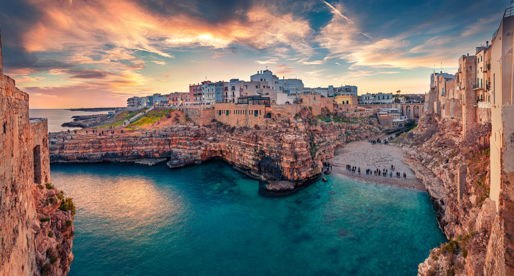 Spectacular spring cityscape of Polignano a Mare town. Incredible evening seascape of Adriatic sea you can see the town and the cliffs and the small beach. 