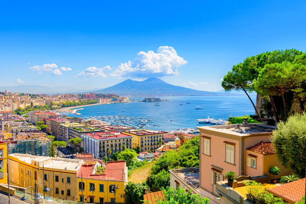  View of the Gulf of Naples from the Posillipo hill with Mount Vesuvius far in the background and some pine trees in foreground.