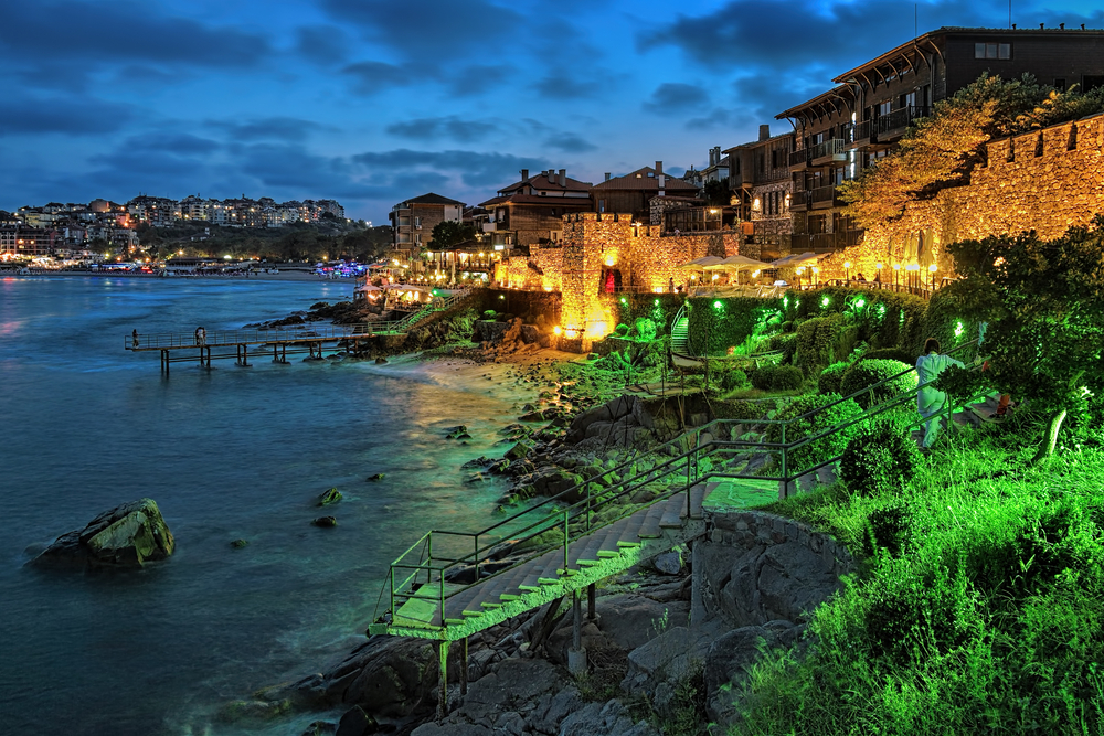 Evening view of Old Town of Sozopol (former ancient town of Apollonia) with Southern Fortress Wall and Tower in the yellow-green illumination, Bulgaria